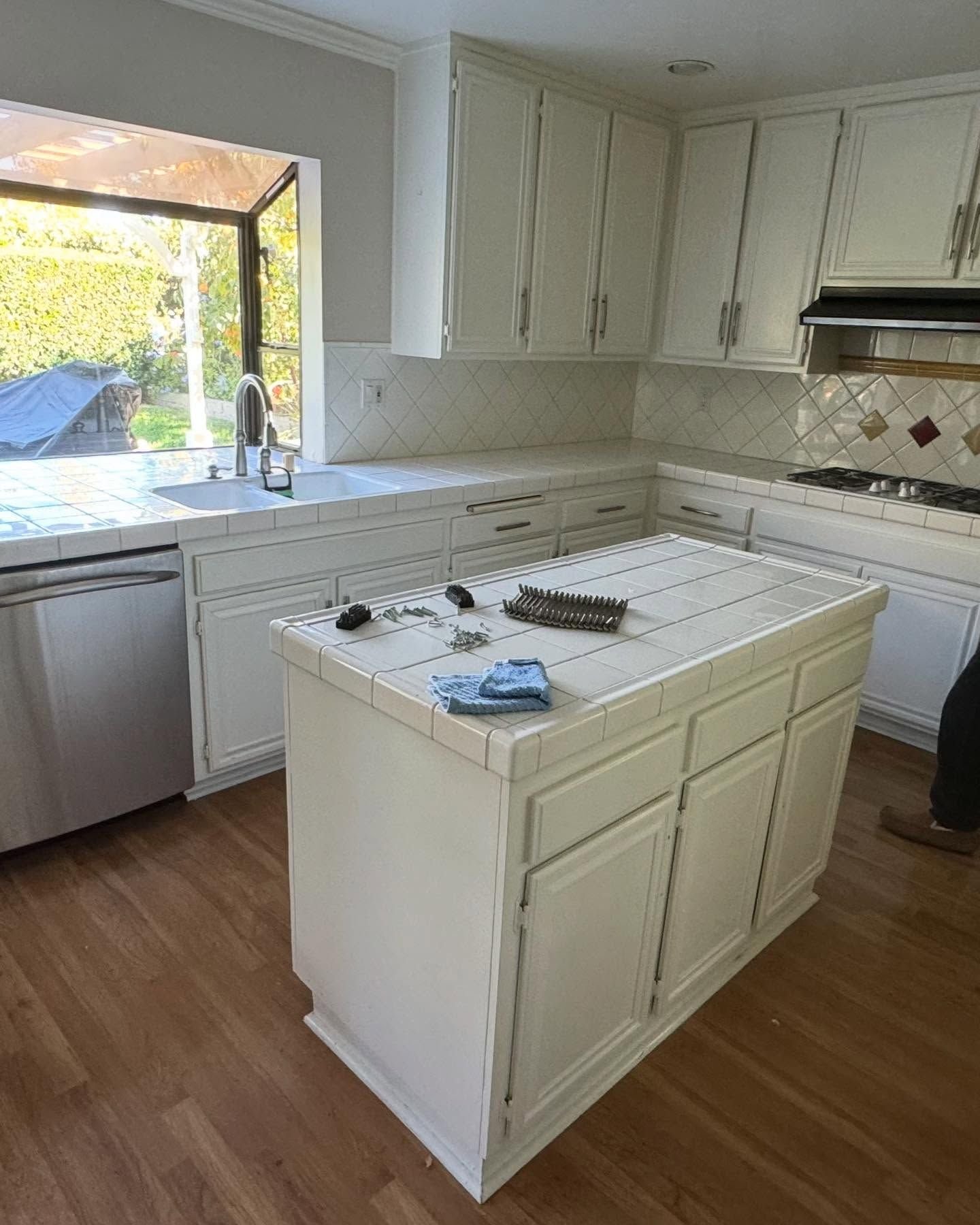 A kitchen with white cabinets and a large island in the middle