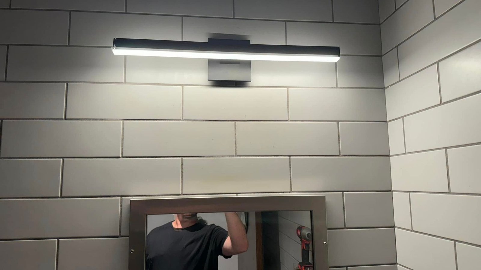A man is looking at himself in a bathroom mirror.